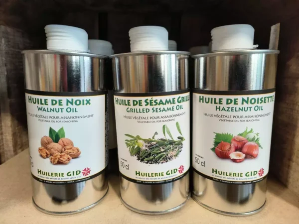 Trois bidons d'Huilerie GID d'huile végétale d'assaisonnement : noix, sésame grillé et noisette, 50 cl chacun.