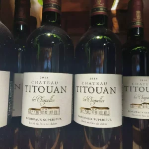 Deux bouteilles de Château Titouan Les Chapelles 2018, vin rouge Bordeaux Supérieur, avec leurs étiquettes détaillées.