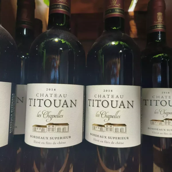 Deux bouteilles de Château Titouan Les Chapelles 2018, vin rouge Bordeaux Supérieur, avec leurs étiquettes détaillées.