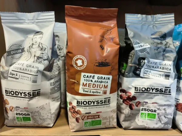 Trois sacs de café en grains Biodyssee, 100% Arabica, 250g, torréfaction artisanale: doux, medium et puissant.