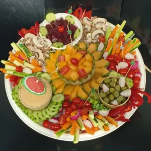 Élégant plateau de crudités variés et fruits frais, incluant melon, betteraves, olives, champignons et légumes croquants. Idéal apéritif.