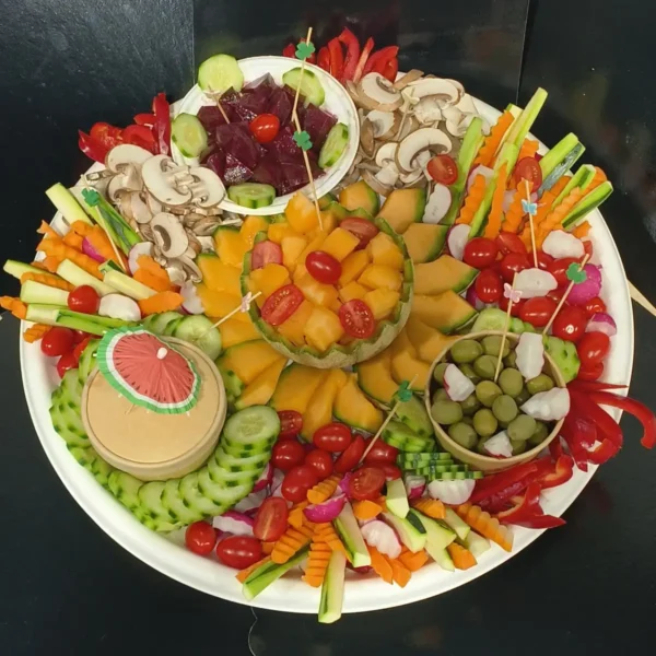 Élégant plateau de crudités variés et fruits frais, incluant melon, betteraves, olives, champignons et légumes croquants. Idéal apéritif.